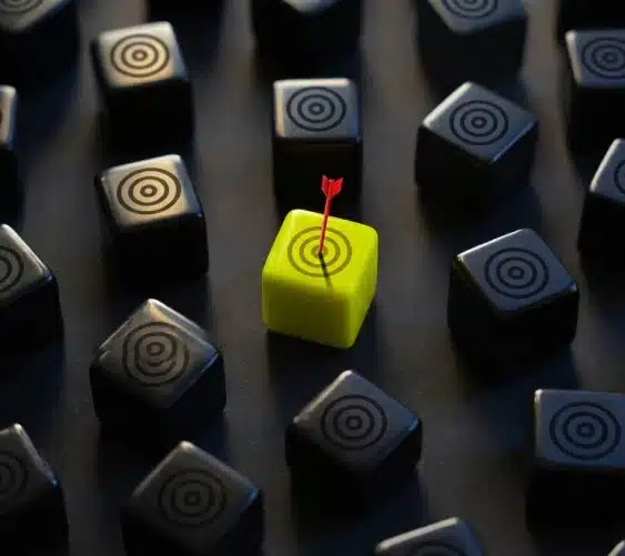 A dart hitting the bullseye of a target-marked cube among a grid of plain cubes