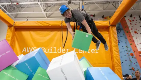 Student ziplining into a foam pit at an AWS Builder Center campus activation