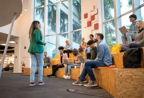 Student presenting to a group seated on campus lounge steps
